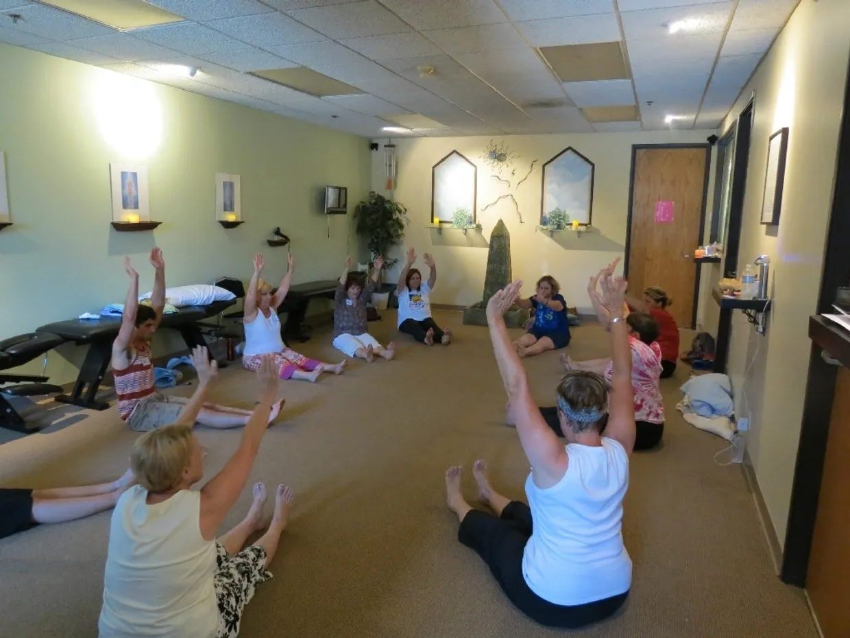 rs=w_1240,cg_true,m A group of people sitting in a room with their hands raised.