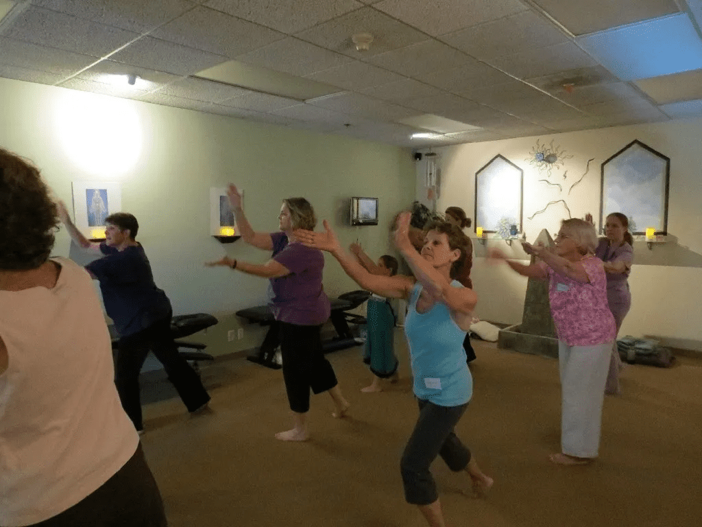 A group of people in the room doing different exercises.