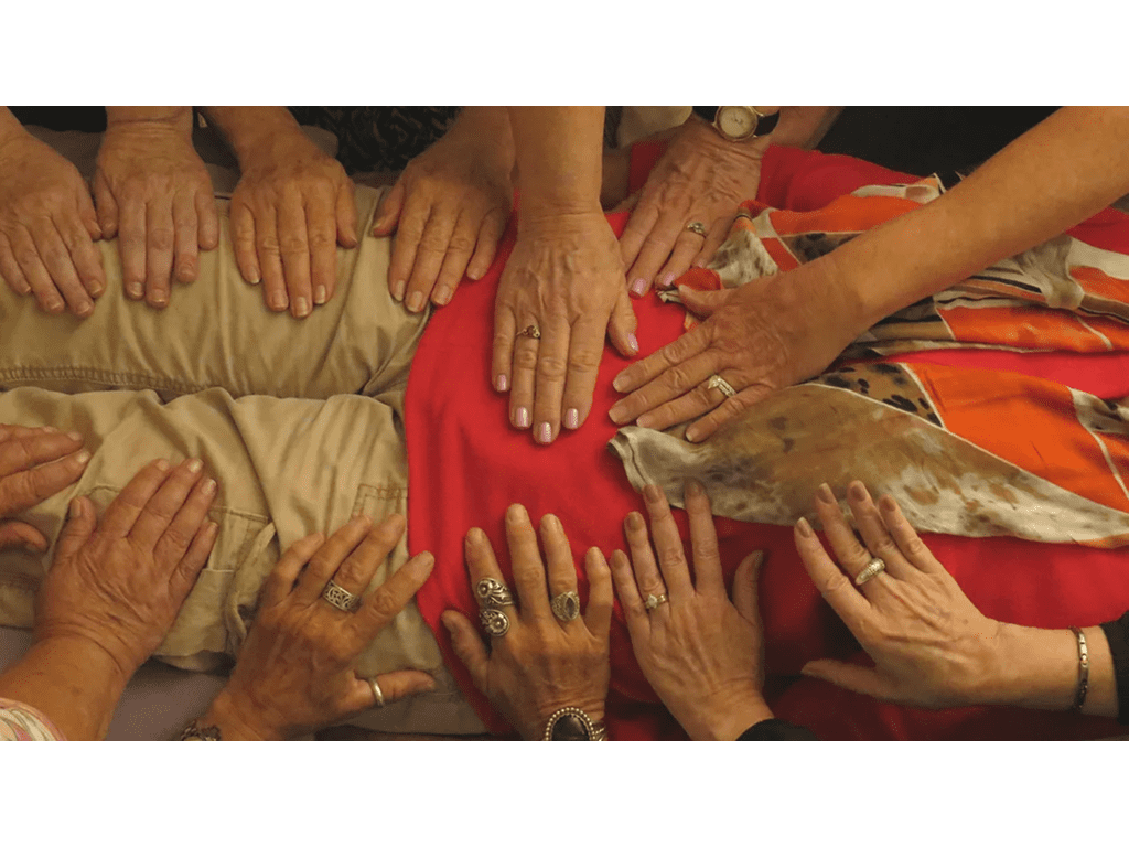 A group of people with their hands on top of each other.