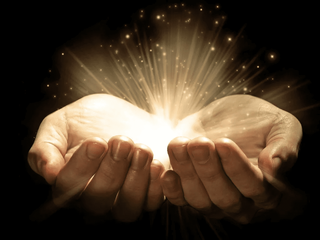 A person holding their hands open with light coming out of them.