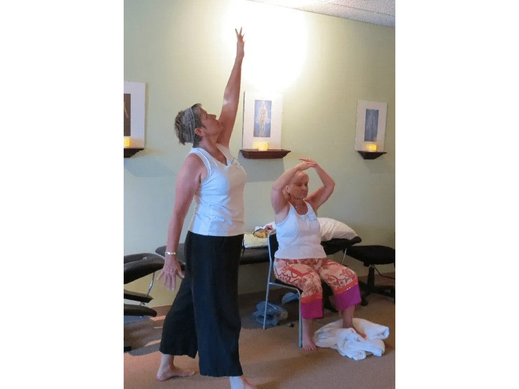 Two women are doing yoga in a room.