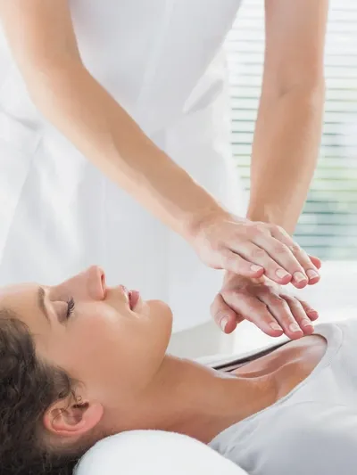 A woman getting her hands placed on top of another person.